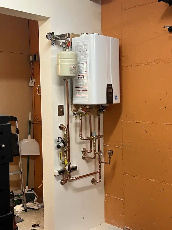 Plumbing technician inspecting water heater connections in Wormleysburg